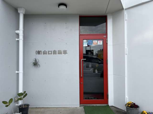 赤い扉が事務所の入り口の目印です。中に入ると左手に事務所があります。